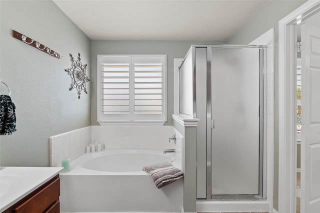 full bath with a bath, vanity, and a stall shower