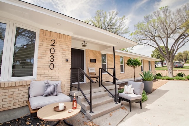 doorway to property with brick siding and covered porch