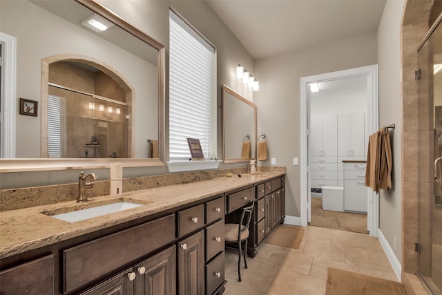 bathroom with a sink, tile patterned floors, double vanity, and a stall shower