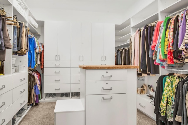 walk in closet featuring light colored carpet