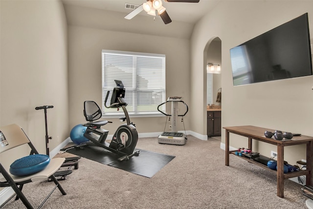 workout room with visible vents, baseboards, arched walkways, a ceiling fan, and light carpet
