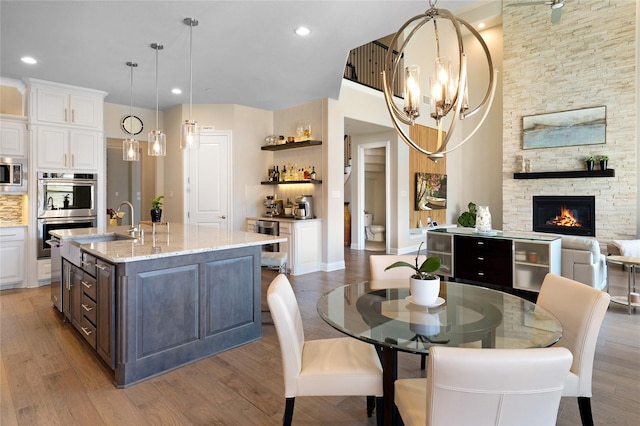 801 Ivy Glen Ct, Prosper, TX 75078 - interior space featuring light stone counters, open shelves, wood finished floors, stainless steel appliances, and white cabinets