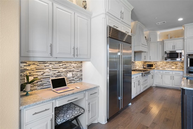 801 Ivy Glen Ct, Prosper, TX 75078 - kitchen featuring tasteful backsplash, built in appliances, white cabinetry, dark wood-type flooring, and visible vents