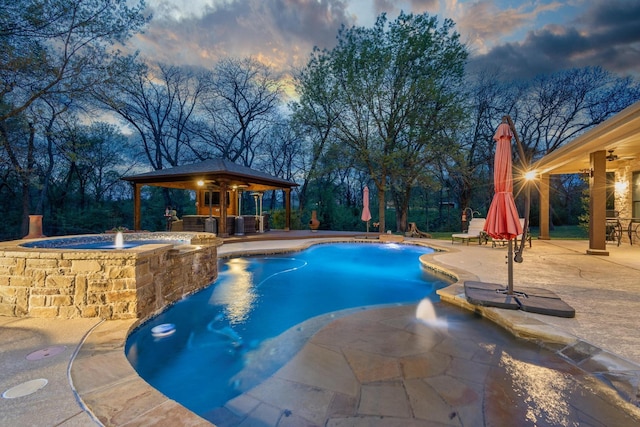 pool at dusk featuring a patio area, a gazebo, a pool with connected hot tub, and a ceiling fan