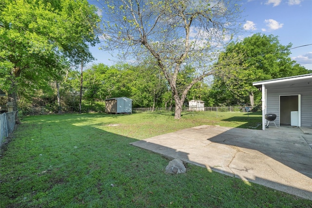 view of yard featuring an outdoor structure, a patio area, a shed, and a fenced backyard