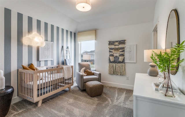 bedroom with a nursery area, baseboards, and carpet floors