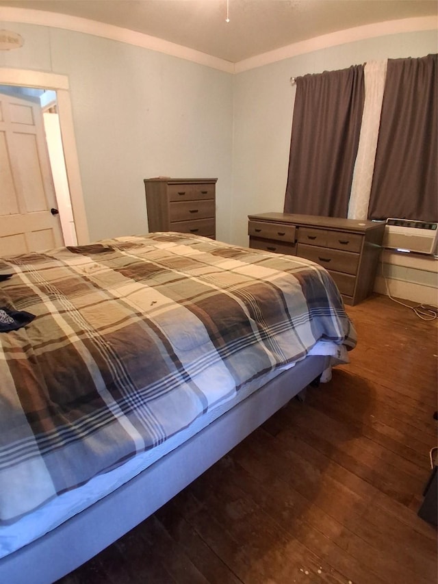 bedroom featuring crown molding and wood finished floors
