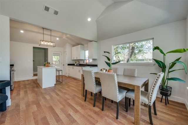 dining area featuring visible vents, light wood finished floors, recessed lighting, and lofted ceiling