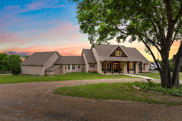 view of front of home featuring a porch, a front lawn, and curved driveway