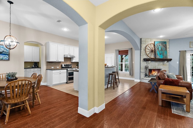 interior space with wood finished floors, visible vents, a fireplace, and a notable chandelier
