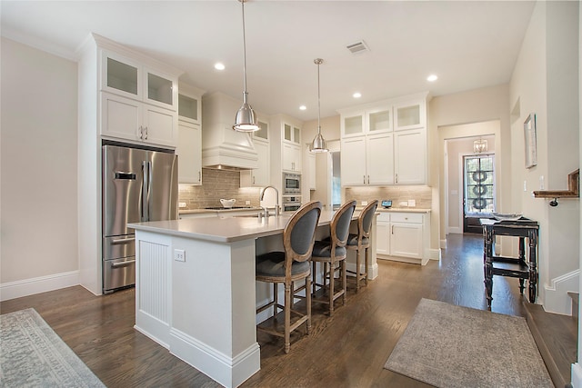 2208 Tremont Blvd, Mckinney, TX 75071 - kitchen with stainless steel appliances, a kitchen island with sink, dark wood-style floors, backsplash, and light countertops