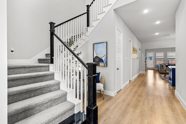 entryway with recessed lighting, baseboards, light wood-type flooring, and stairs