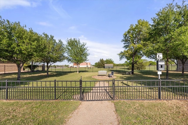 view of community with a yard, fence, and a gate