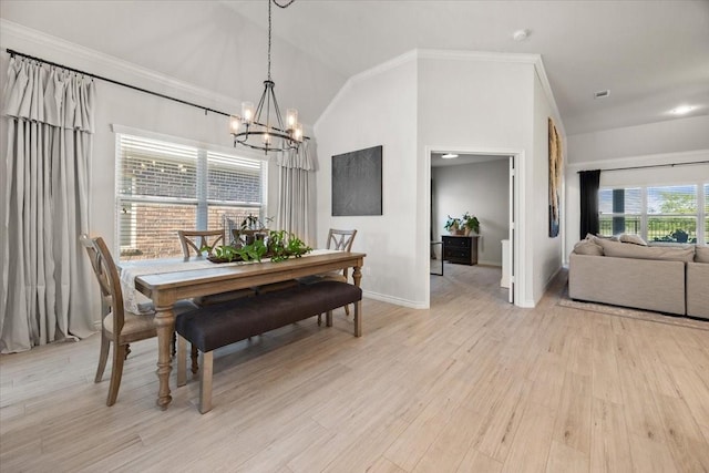 dining area featuring baseboards, an inviting chandelier, ornamental molding, light wood finished floors, and lofted ceiling