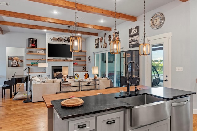 kitchen with white cabinets, visible vents, a sink, and light wood-style flooring