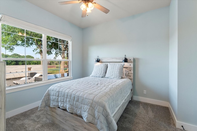 carpeted bedroom featuring baseboards and a ceiling fan