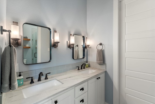 full bathroom featuring a sink, double vanity, and a stall shower