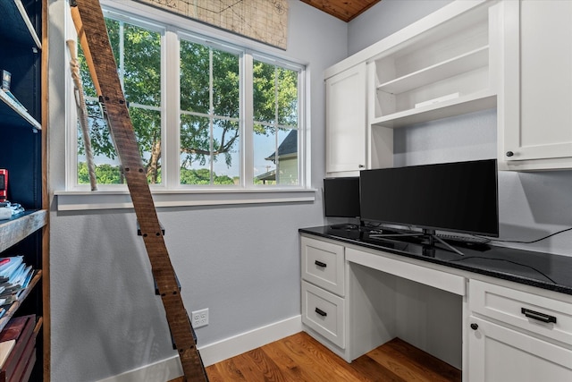office area featuring built in study area, light wood-style floors, and baseboards