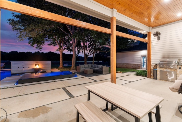 patio terrace at dusk with outdoor lounge area and area for grilling