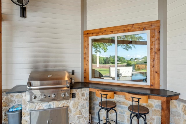view of patio featuring a grill, outdoor wet bar, and an outdoor kitchen