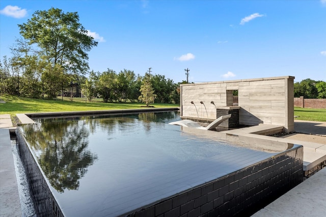 view of swimming pool featuring a water view and a lawn