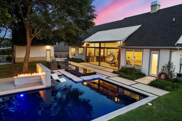 outdoor pool featuring an outdoor living space with a fire pit and a patio