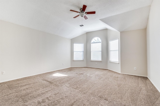 spare room with visible vents, ceiling fan, carpet, a textured ceiling, and vaulted ceiling