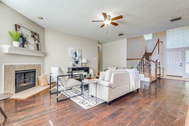 living room with wood finished floors, a ceiling fan, visible vents, and stairway