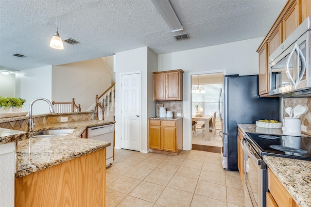 kitchen with a sink, backsplash, visible vents, and stainless steel appliances
