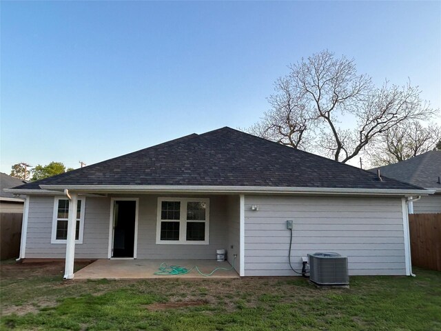 1985 W Bond St, Denison, TX 75020 - back of house with central AC unit, a shingled roof, a yard, a patio area, and fence