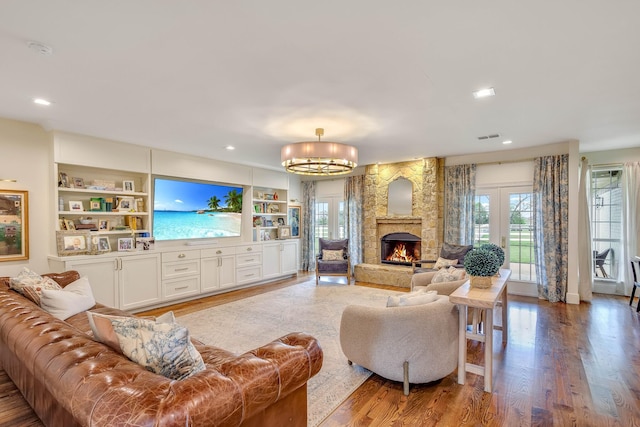 860 Prairie Trl, Argyle, TX 76226 - living area with a stone fireplace, a healthy amount of sunlight, and wood finished floors