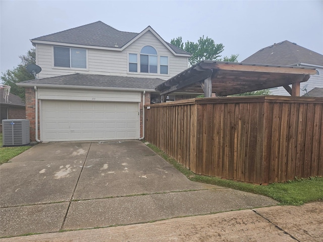 exterior space featuring central AC unit, a garage, fence, concrete driveway, and roof with shingles