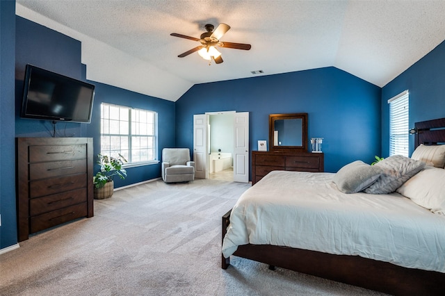bedroom with lofted ceiling, carpet, a textured ceiling, a ceiling fan, and ensuite bathroom