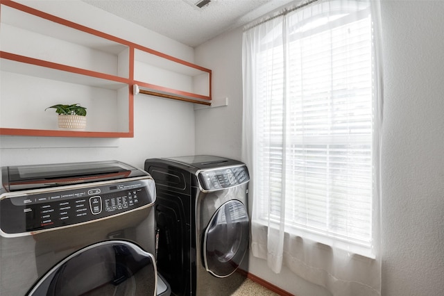 clothes washing area featuring independent washer and dryer and a textured ceiling