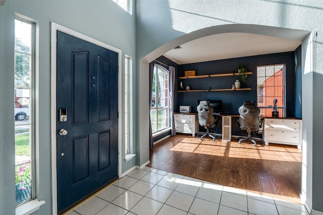 tiled entryway with arched walkways and plenty of natural light