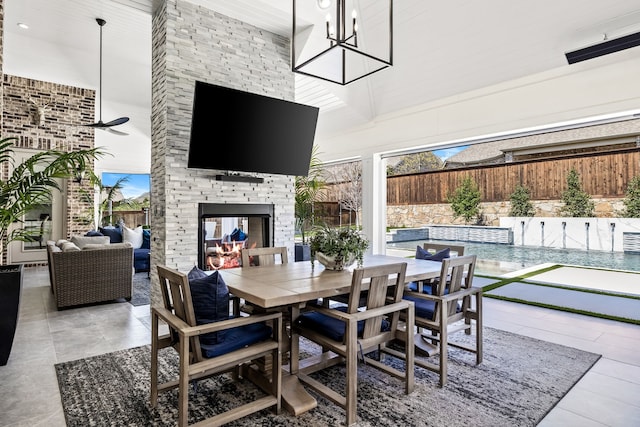 view of patio / terrace featuring an outdoor living space with a fireplace, outdoor dining space, and fence