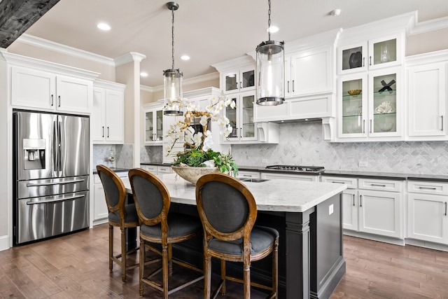 kitchen featuring dark wood-type flooring, a kitchen island with sink, ornamental molding, and stainless steel appliances