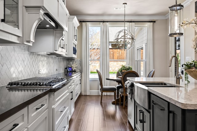 kitchen with a chandelier, plenty of natural light, ornamental molding, and backsplash