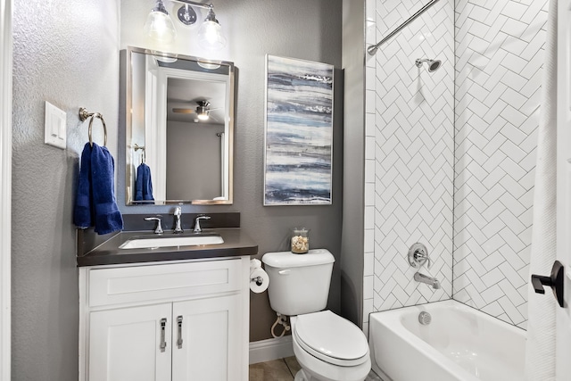 bathroom with toilet, vanity, a textured wall, and shower / bathtub combination