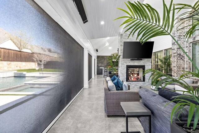 view of patio / terrace with an outdoor living space with a fireplace and fence