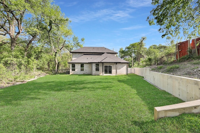 back of property with a yard and a fenced backyard