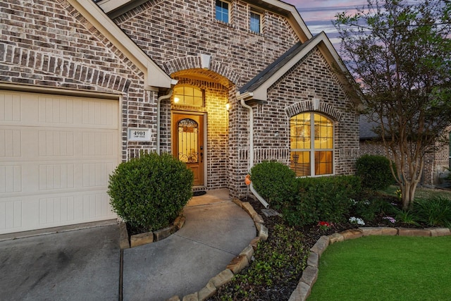 4901 Camp Verde Cir, Sherman, TX 75092 - exterior entry at dusk featuring brick siding and a garage