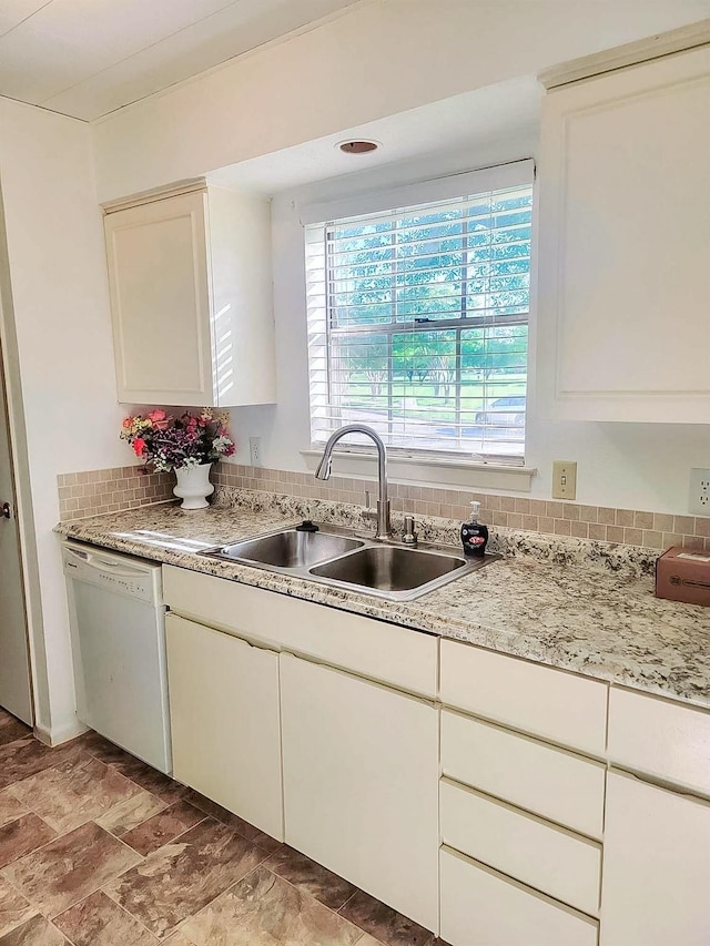 3205 Parkside Dr, Mesquite, TX 75150 - kitchen featuring white dishwasher, a sink, white cabinets, and backsplash