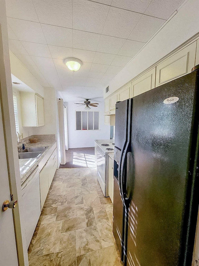 3205 Parkside Dr, Mesquite, TX 75150 - kitchen featuring white appliances, a sink, light countertops, light stone finish flooring, and ceiling fan