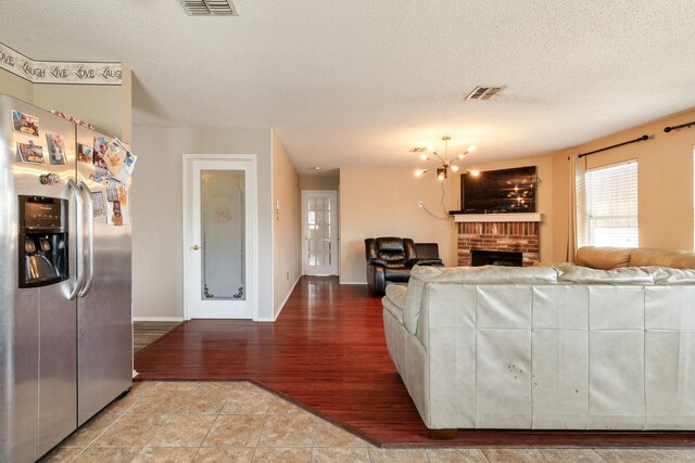 1435 Greenbrook Dr, Rockwall, TX 75032 - living room featuring visible vents, baseboards, wood finished floors, and a textured ceiling