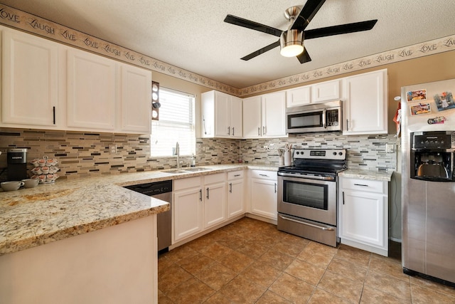 1435 Greenbrook Dr, Rockwall, TX 75032 - kitchen with a textured ceiling, a ceiling fan, white cabinetry, appliances with stainless steel finishes, and a sink