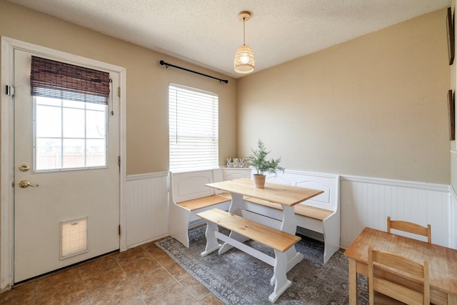 1435 Greenbrook Dr, Rockwall, TX 75032 - dining space with a textured ceiling, a wealth of natural light, and a wainscoted wall