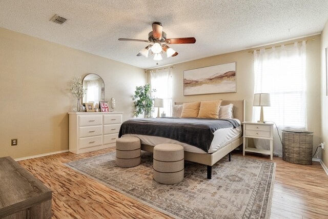 1435 Greenbrook Dr, Rockwall, TX 75032 - bedroom with a ceiling fan, visible vents, light wood-type flooring, and a textured ceiling