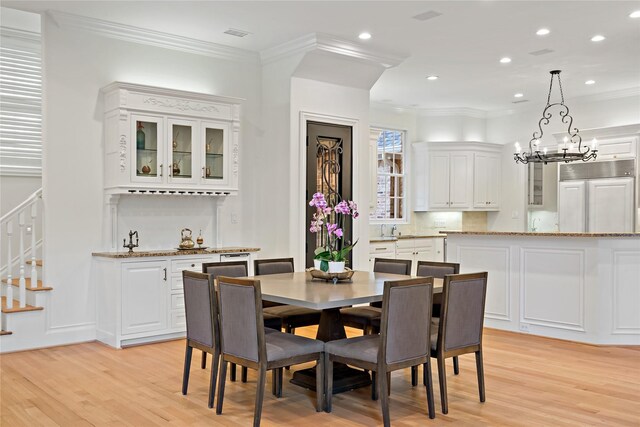dining space with light wood-style flooring, ornamental molding, recessed lighting, stairway, and a notable chandelier