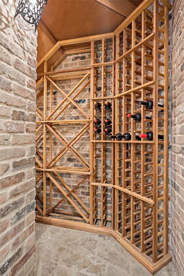 wine room with brick wall and lofted ceiling